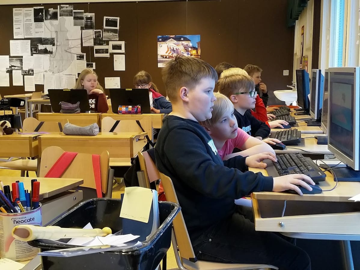 Pojat ja tytöt tietokoneiden ääressä