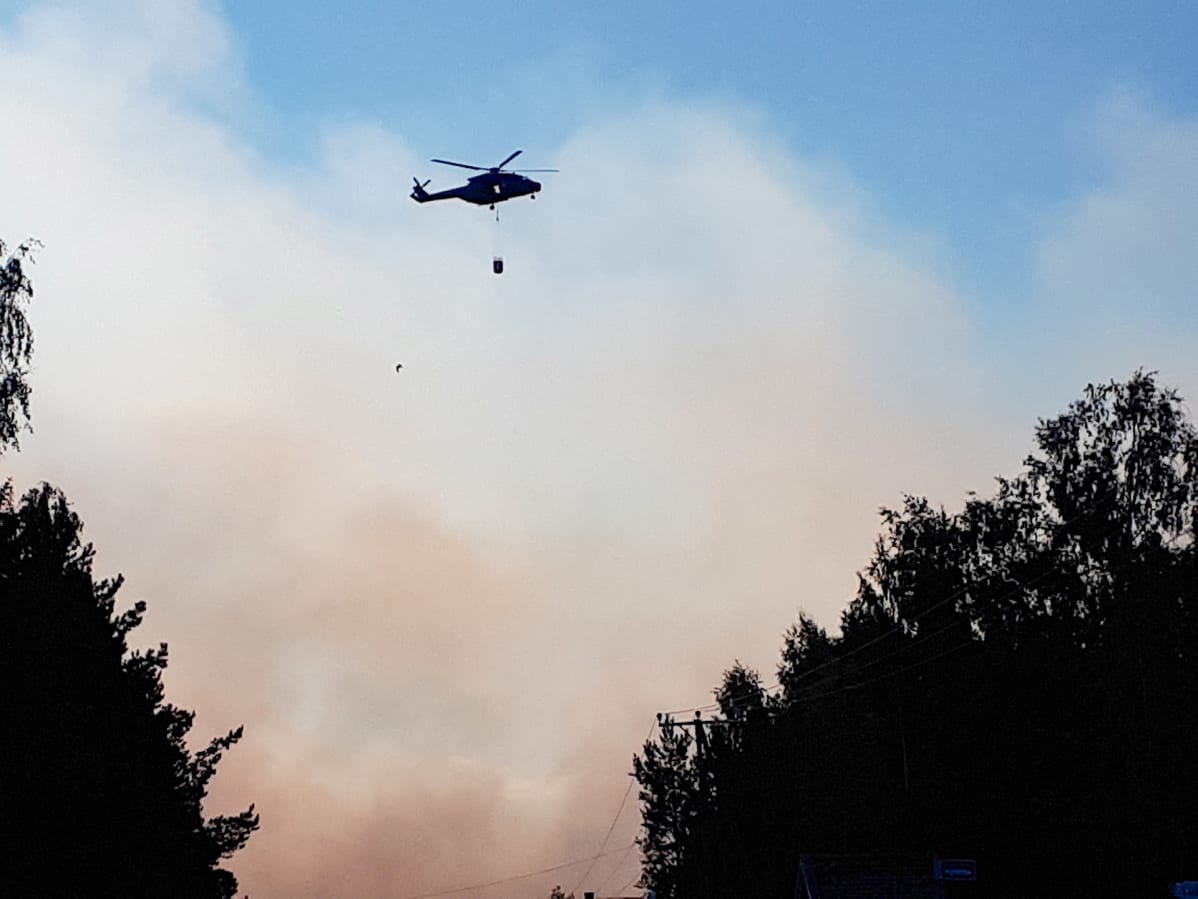 Maastopaloa sammuttaa helikopteri pudottamalla vesilastin maahan.