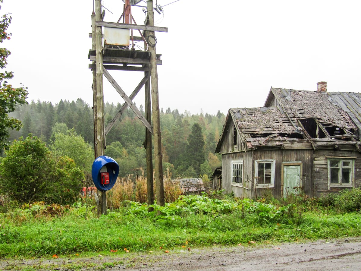 taloja kylän raitilla ja puhelinkoppi sähköpylväässä