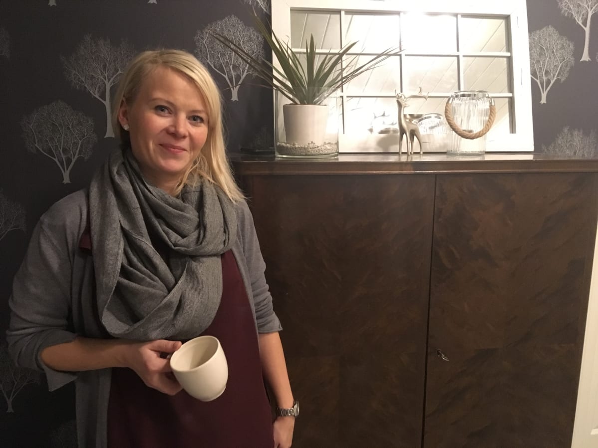 Any Rytkönen kotonaa kahvikuppi kädessä.