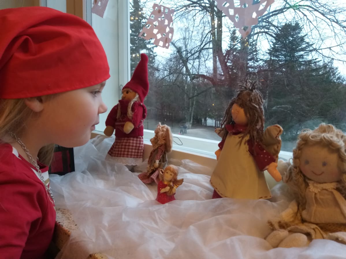 Saana Haapala katselee ikkunasta, näkyykö tonttuja.
