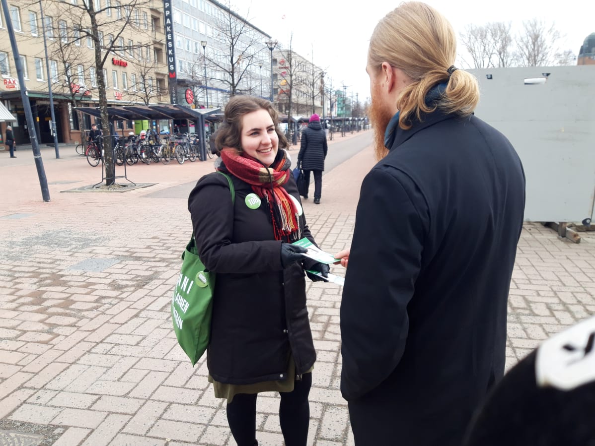 Vihreiden kansanedustajaehdokas Senni Martikainen Iisalmesta jakaa omia kampanjaesitteitään Joensuussa.