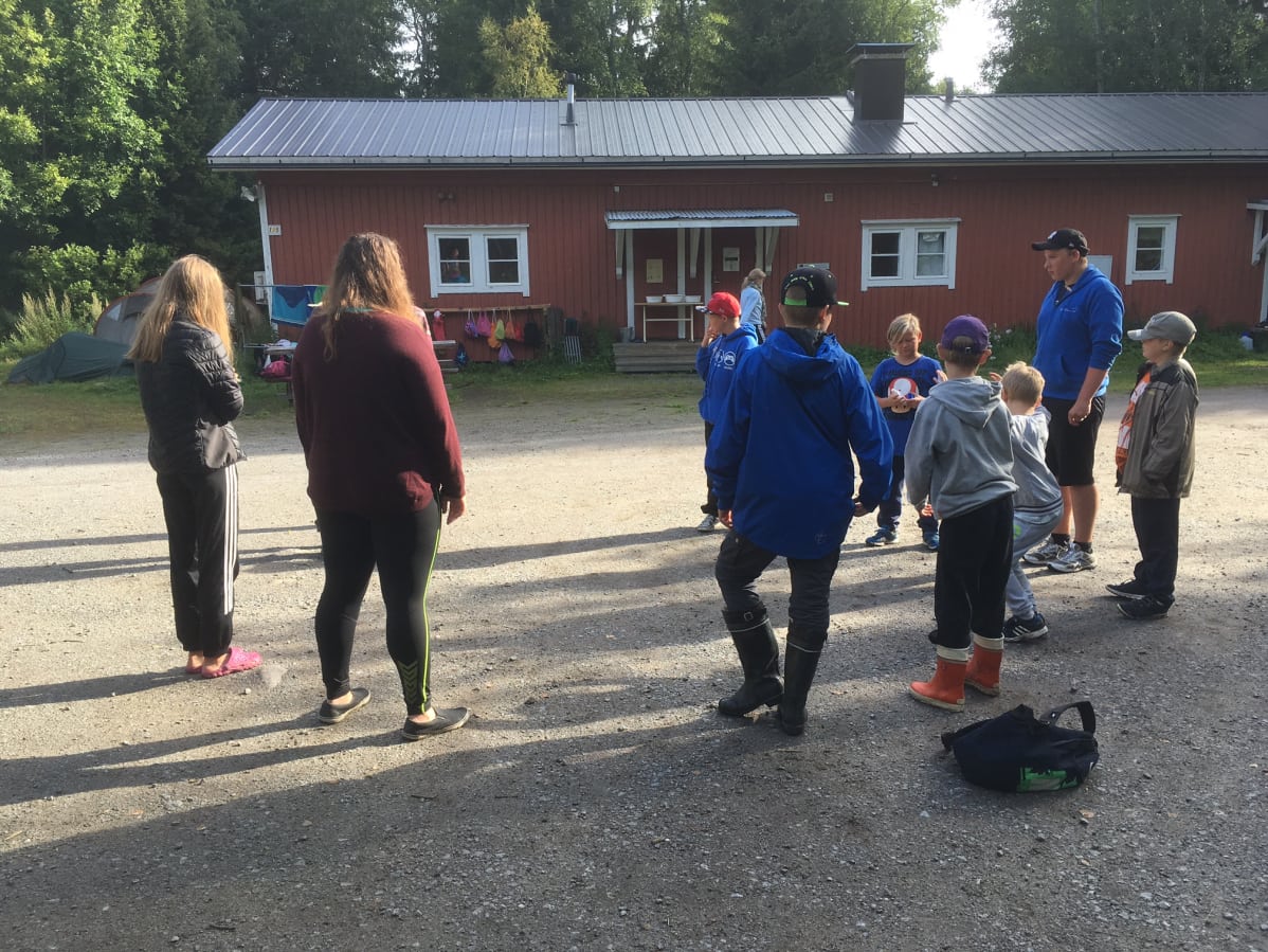 Kielikylpyleirillä lapsia ja ohjaajia Sommarön linnakkeen rakennuksen pihamaalla.