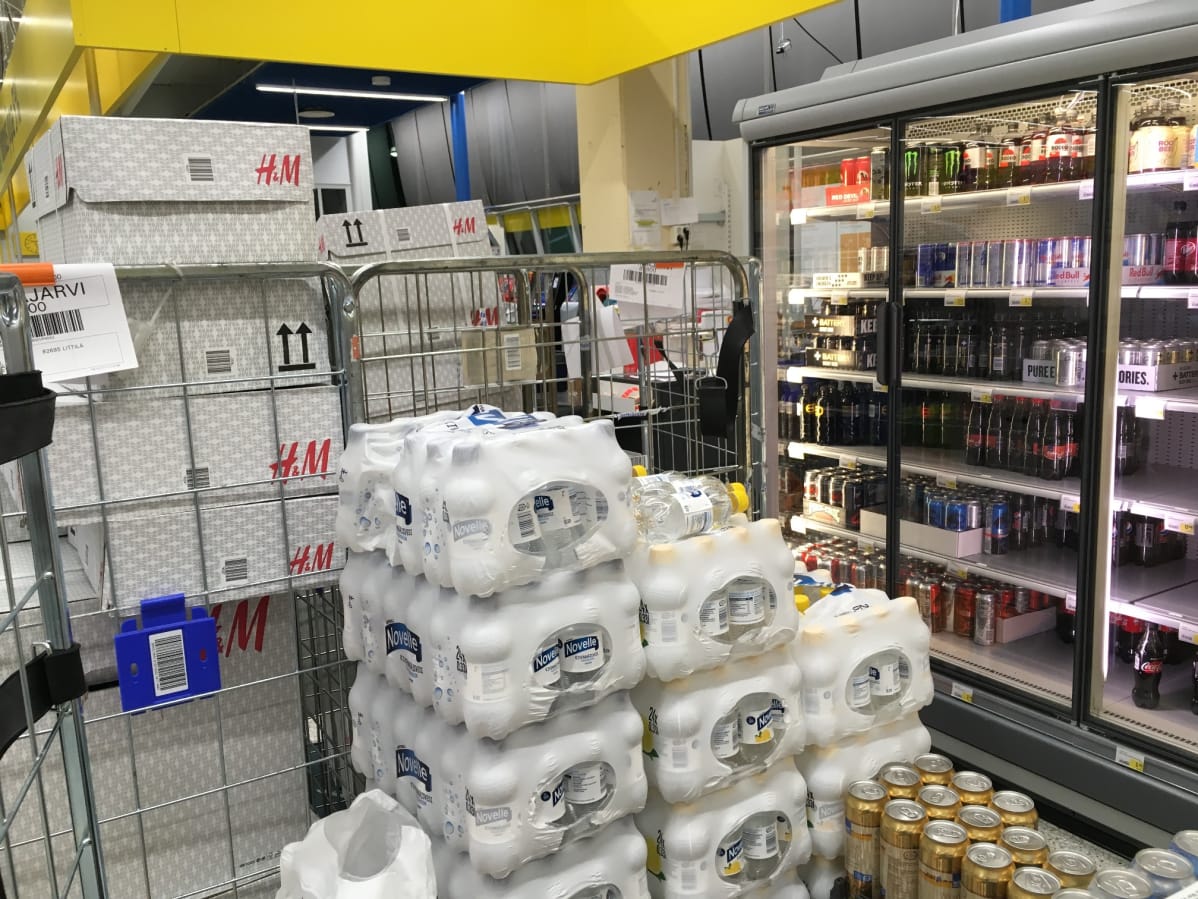 Pakettirullakkoja hyllyjen välissä