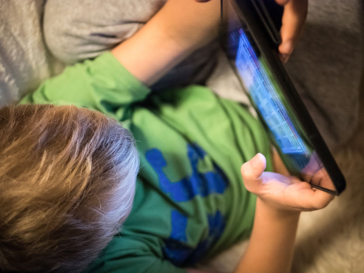 Lapsi pelaa iPadilla nettipeliä.
