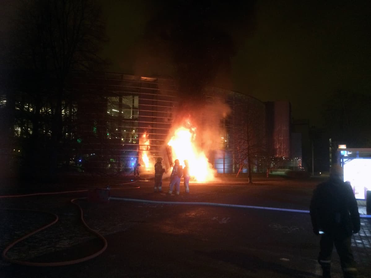 Palomiehiö palavan taideteoksen edessä Helsingin Viikissä.