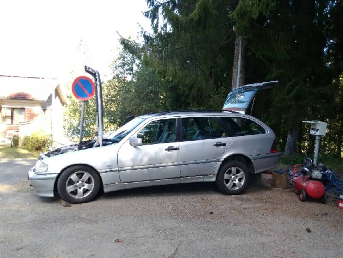 Auto konepelti ja takaluukku avoinna.