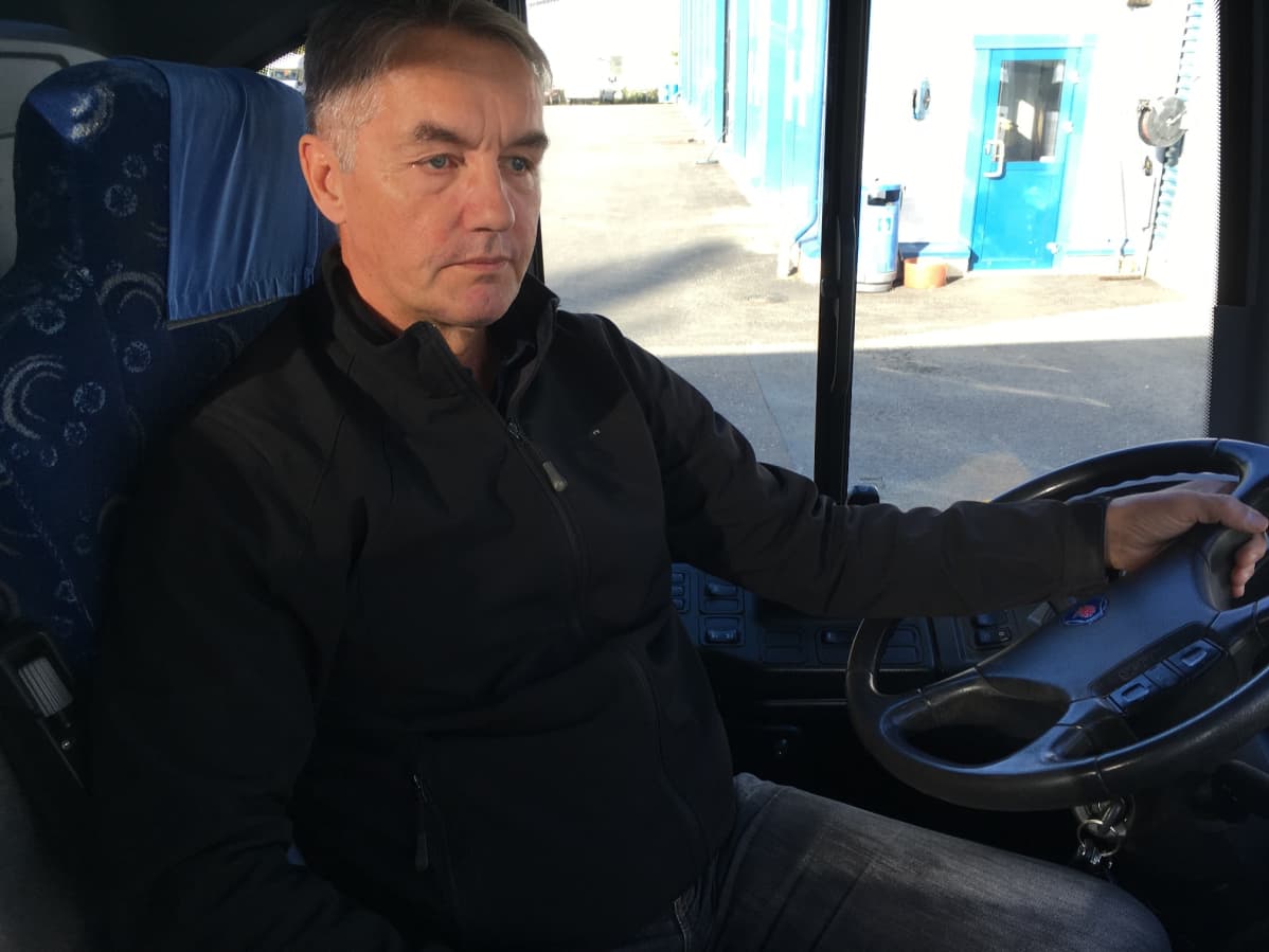 Bussinkuljettaja Ossi Sinkkonen istuu bussissa.