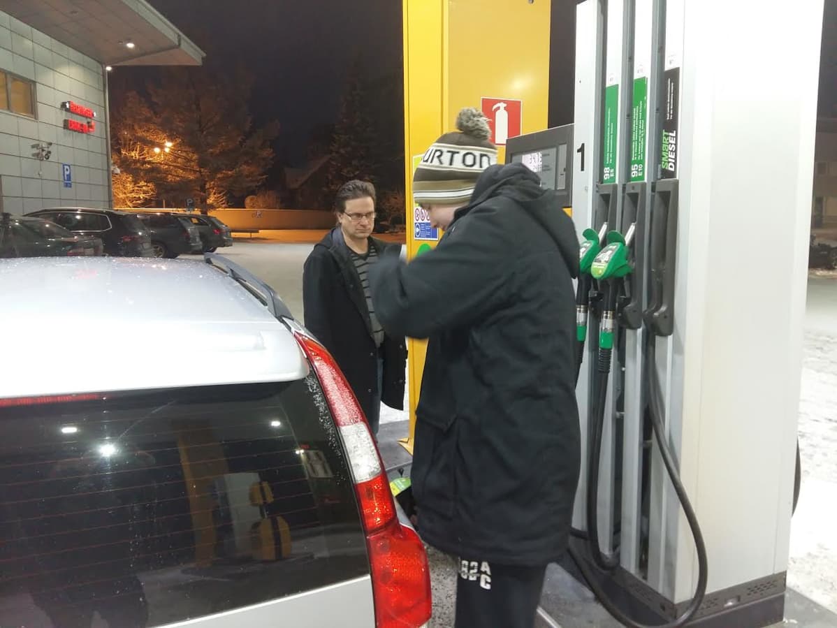Johannes Horila tankkaa. Isä valvoo.