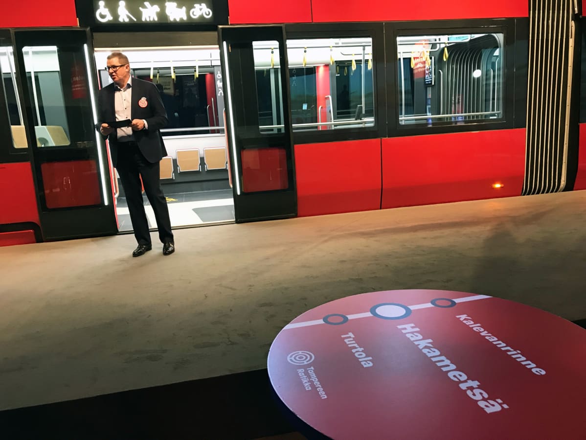 Tampereen Raitiotie Oy:n toimitusjohtaja Pekka Sirviö esittelee ratikan täysikokoista mallia.