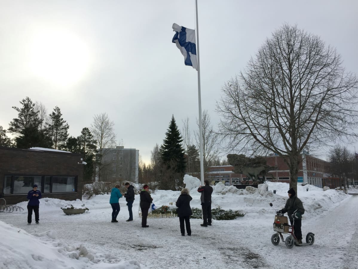 Ihmisiä tuomassa kynttilöitä