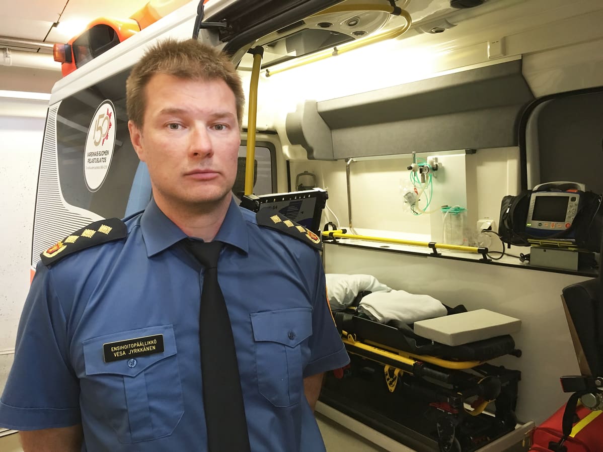 Vesa Jyrkkänen seisoo ambulanssin vieressä.