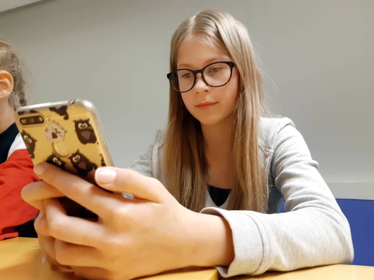 5.-luokkalainen Taika Partanen selaa sosiaalista mediaa puhelimellaan.