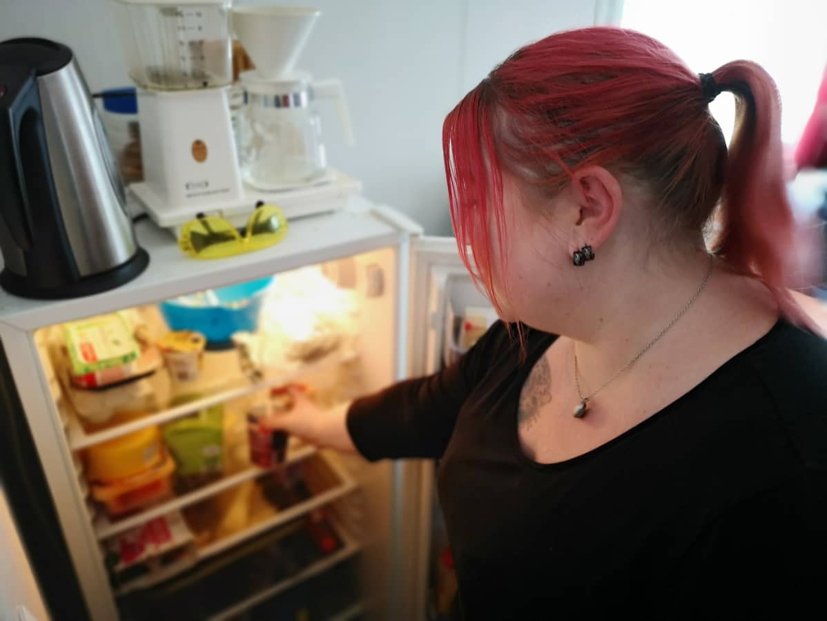 Tarja Venäläinen katsoo jääkaappiin.