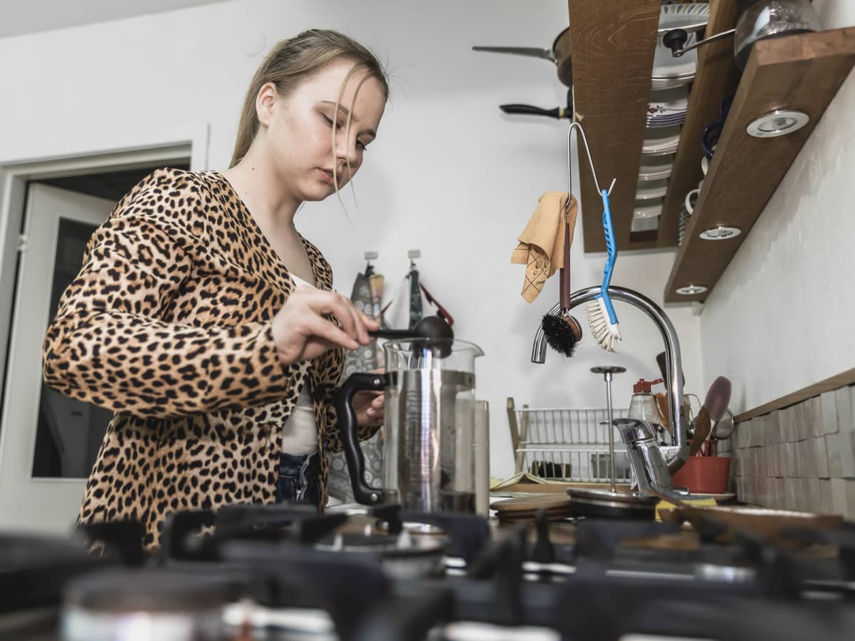 Amalia Paananen laittaa kahvinpuruja kahvinkeittimeen.