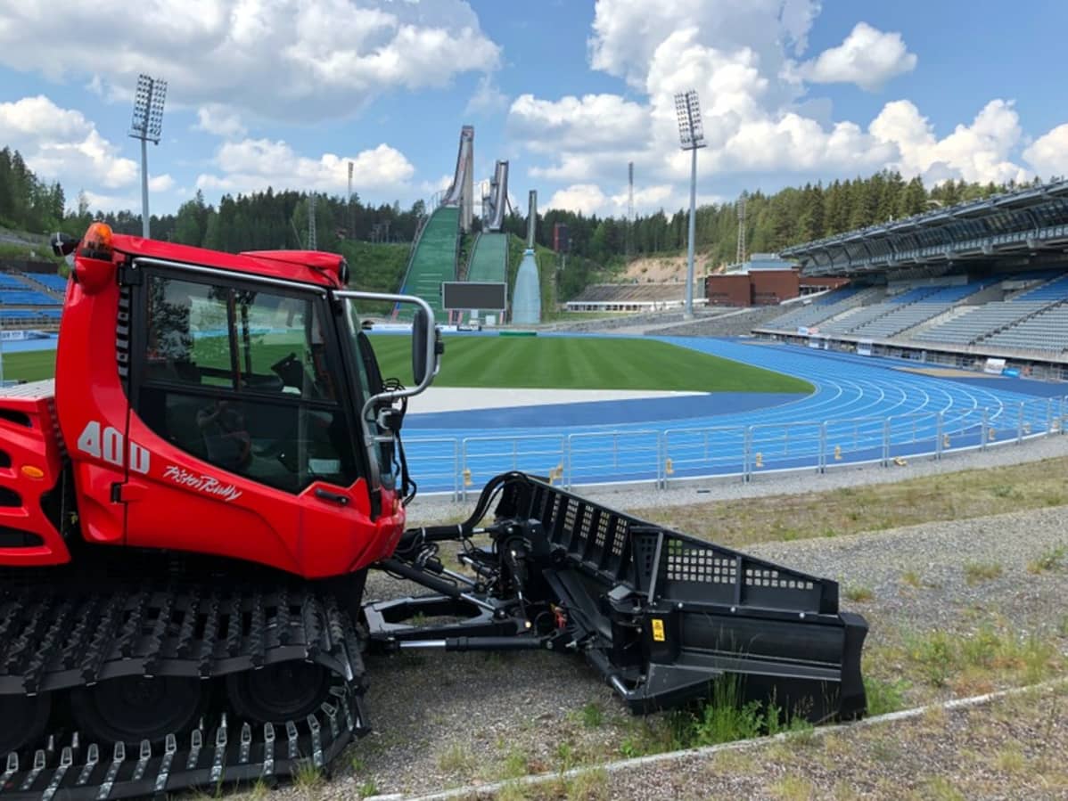 Pysäköity latukone seisoo kesäisen stadionin reunalla.