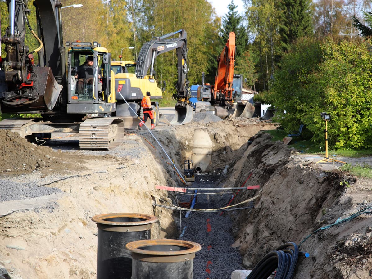 Kaivinkone ja työmiehiä vesijohtosaneeraustyömaalla Kemissä.