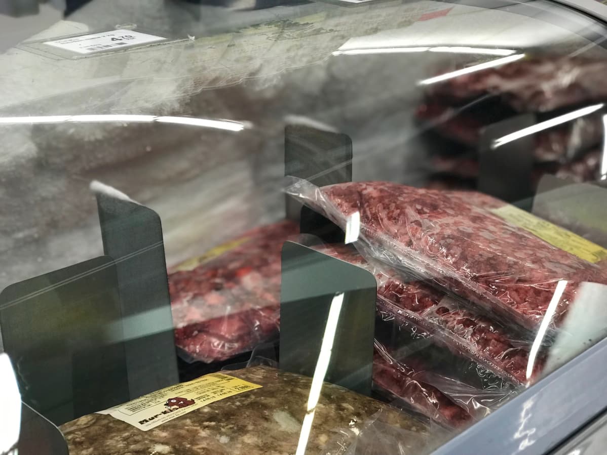 Pakasteallas täynnä koiran ruokaa eläinruokakaupassa.