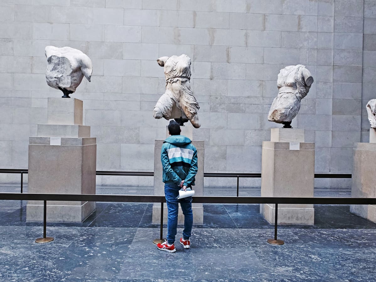 Turisti katselee Parthenon-temppelin veistoksia British Museumissa.
