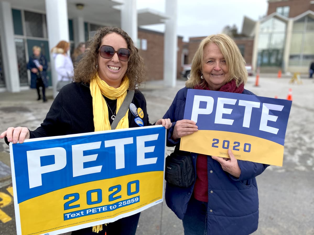 Pete-kylttejä kantavat rouvat.