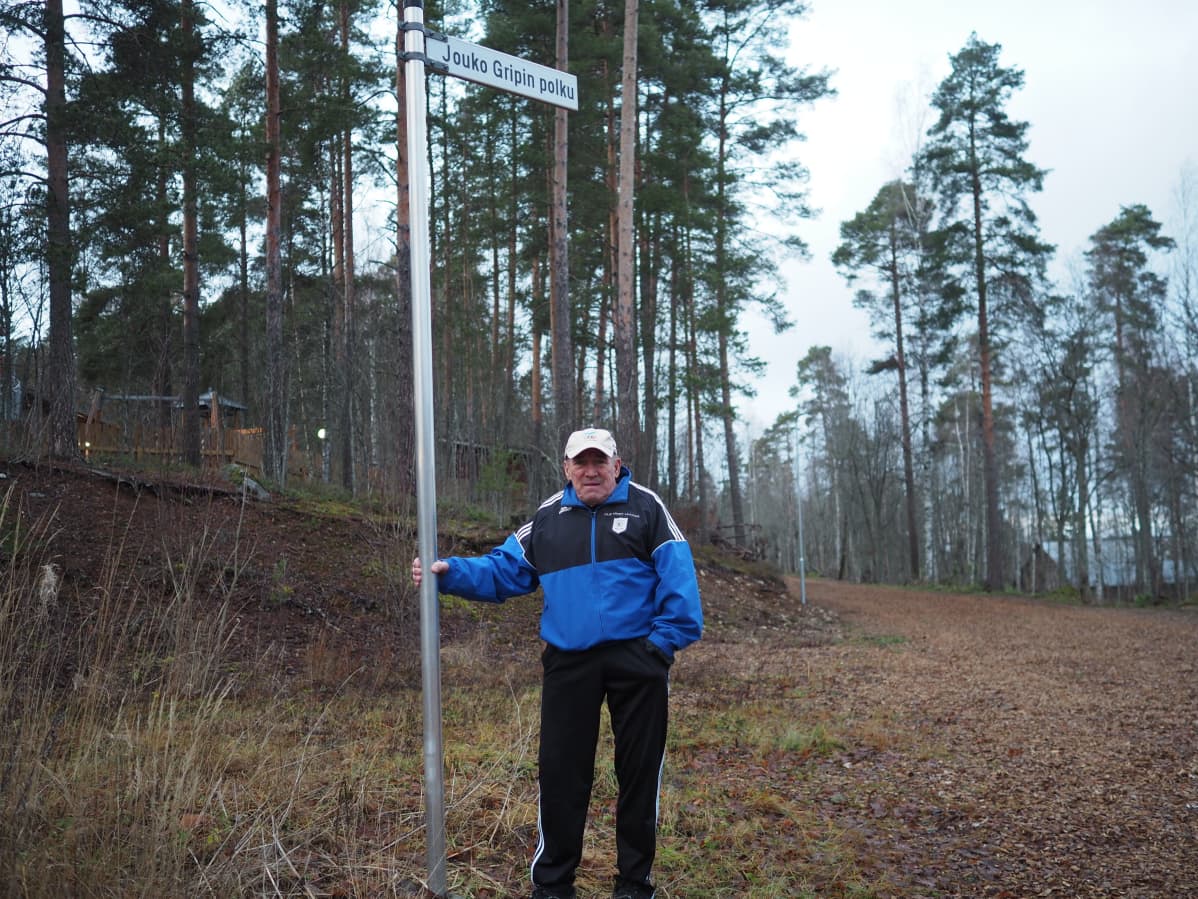 Jouko Grip nimikkokylttinsä juurella.