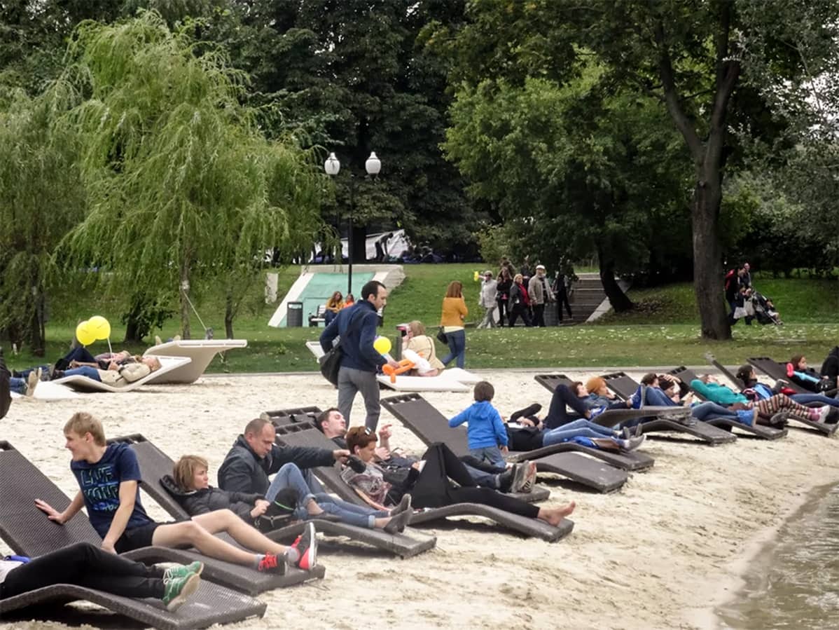 ihmisiä lepotuoleissa puistossa