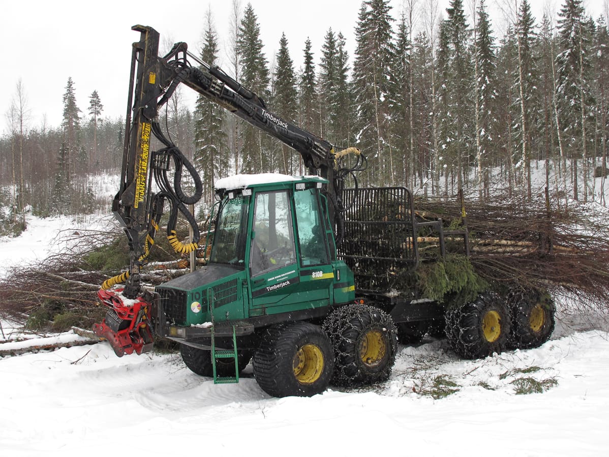 Vihreän värinen Timberjack-metsäkone kerää hakepuuta.