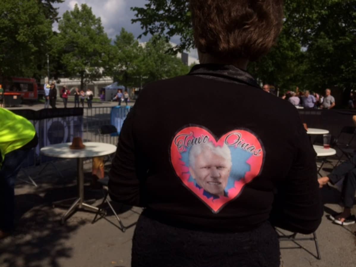 Irja Huttusen takin selkämystä koristaa Teuvo Oinaan kuva.