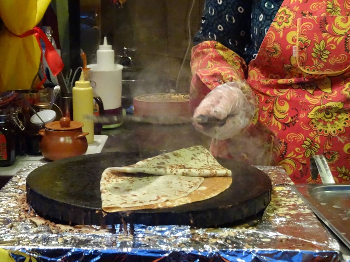 Naisen käsi ja ohut, letunnäköinen blini.