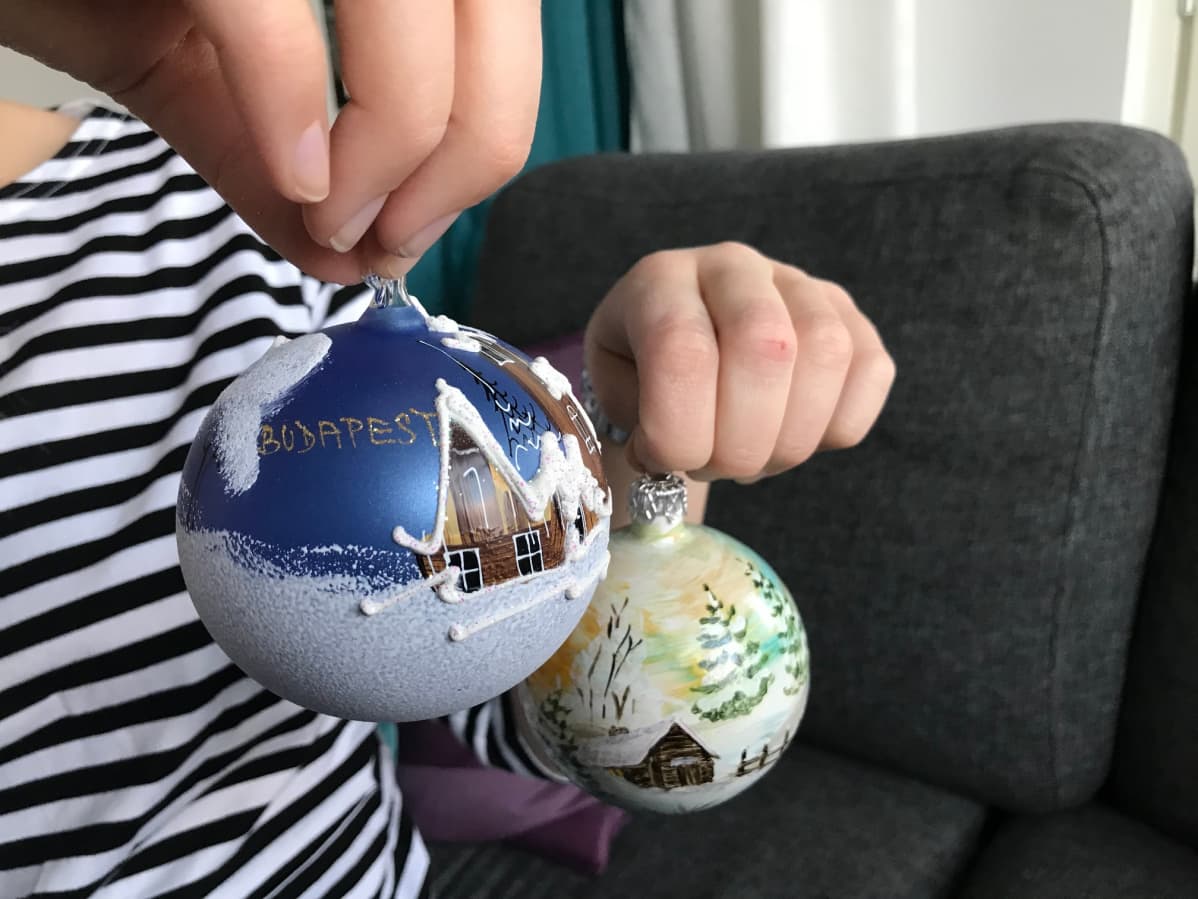 Sininen, kirkolla koristettu joulupallo Budapestistä ja vaalea, latomaisemainen pallo Gdanskista