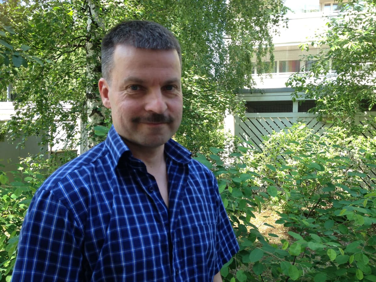 Tanssiteatteri Glims & Glomsin perustajajäsen Tuomo Railo kuvattuna ulkona, taustalla vehreä kesäpiha.