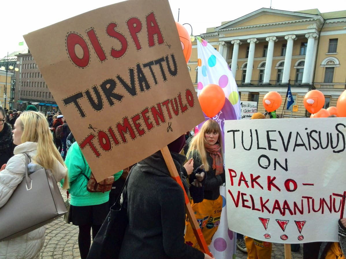 kylttejä opintotukimielenosoituksessa: "oispa turvattu toimeentulo", "tulevaisuus on pakkovelkaantunut"