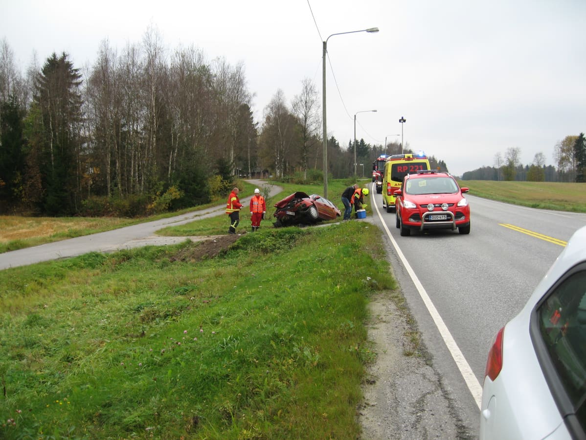 Henkilöauto ojassa, ensihoito ja pelastuslaitoksen autoja paikalla.
