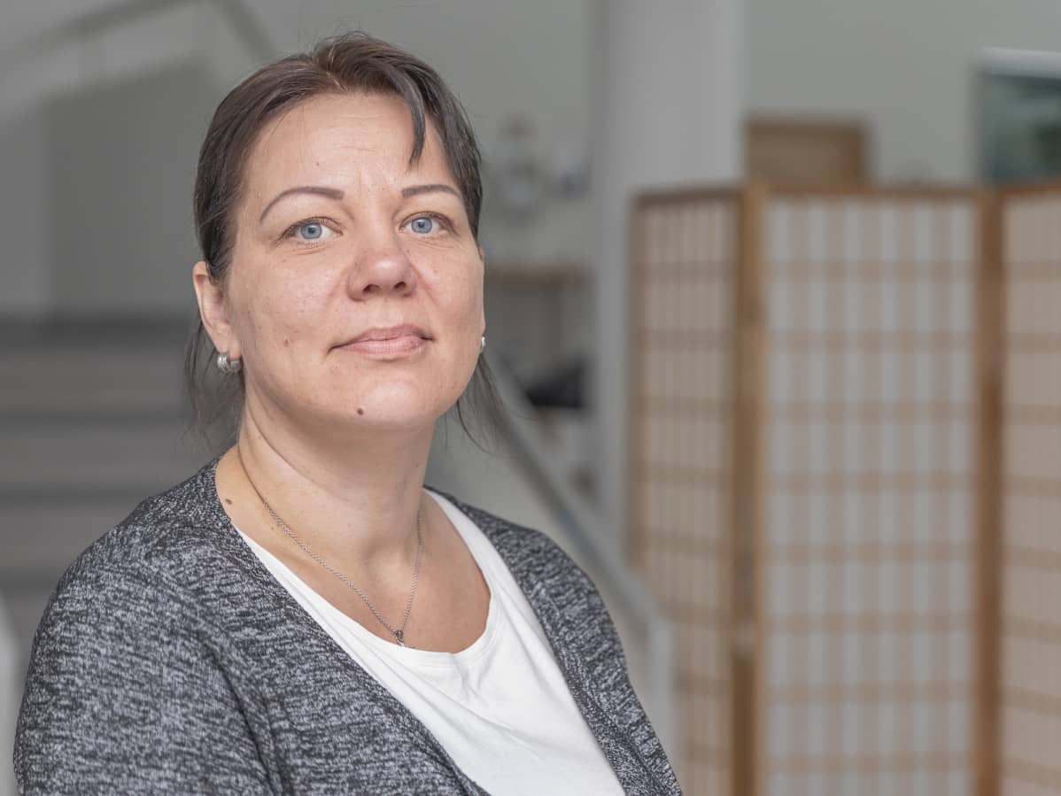 Nainen katsoo kameraan.