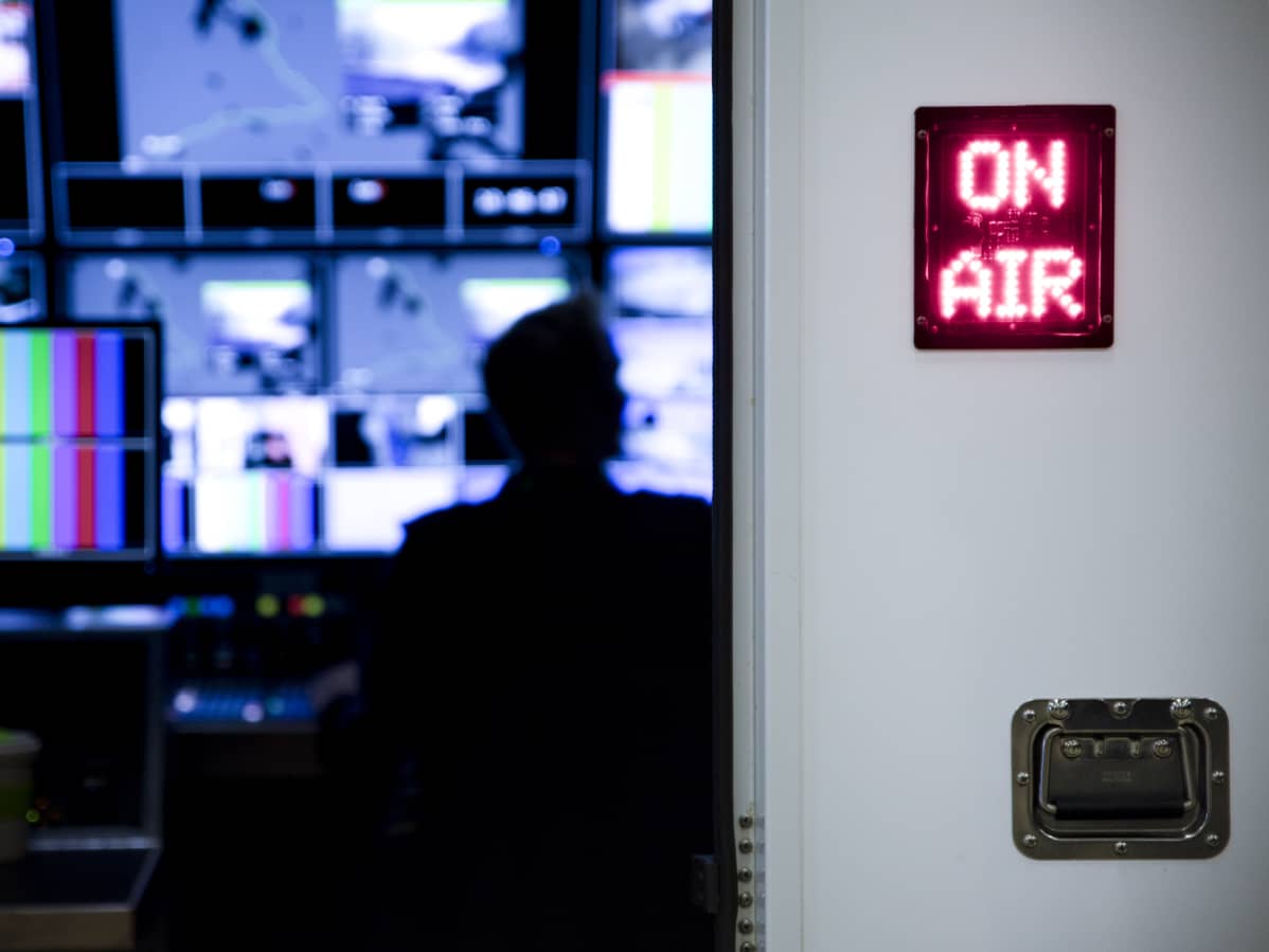 Kuvaruutuja tv-ohjaamossa, on air -kyltissä palaa valo.
