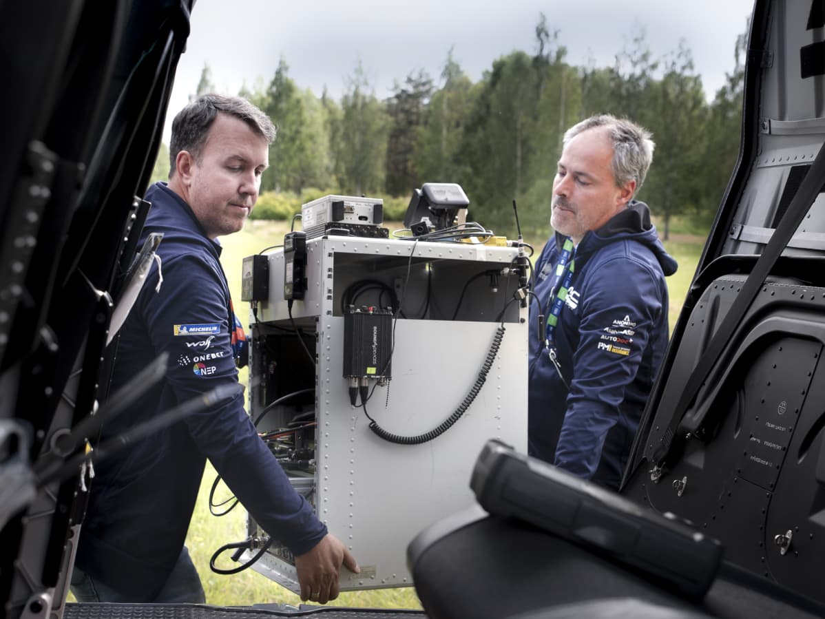 Clint Fast ja Bart Van Aert kantavat tv-lähetintä helikopteriin.