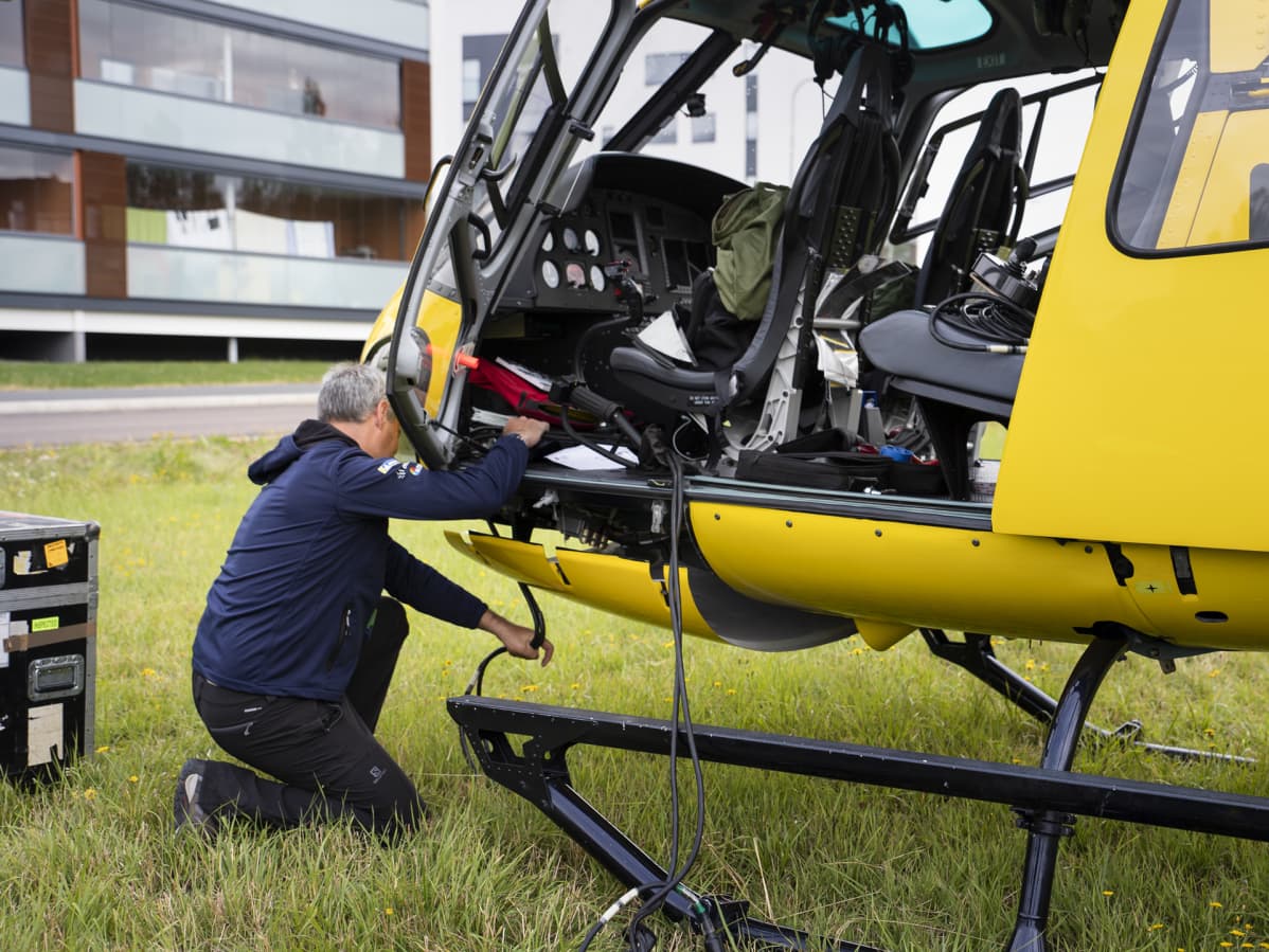 Bart Van Aert kiinnittää kuvauskalustoa helikopteriin.