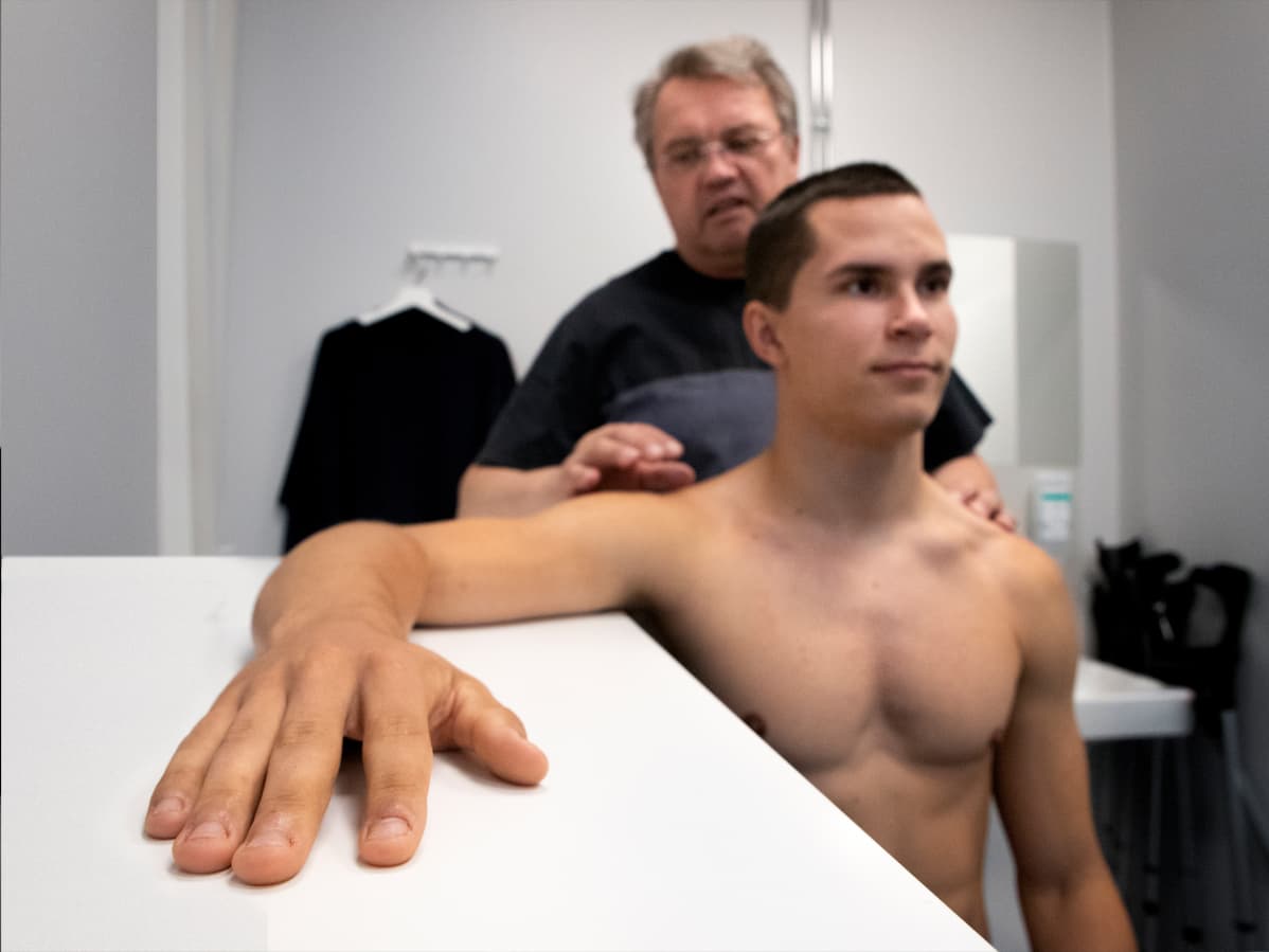 Urheilufysioterapeutti Peter Halén ohjaa vastaanotollana seiväshyppääjä Urho Kujanpäätä lepuuttamaan hartioita.