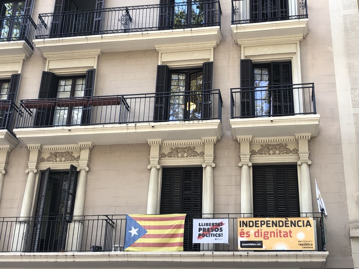 Barcelonan parvekkeilla heiluvat Katalonian liput. Banderolleissa vaaditaan poliittisten vankien vapauttamista ja itsenäisyyttä.