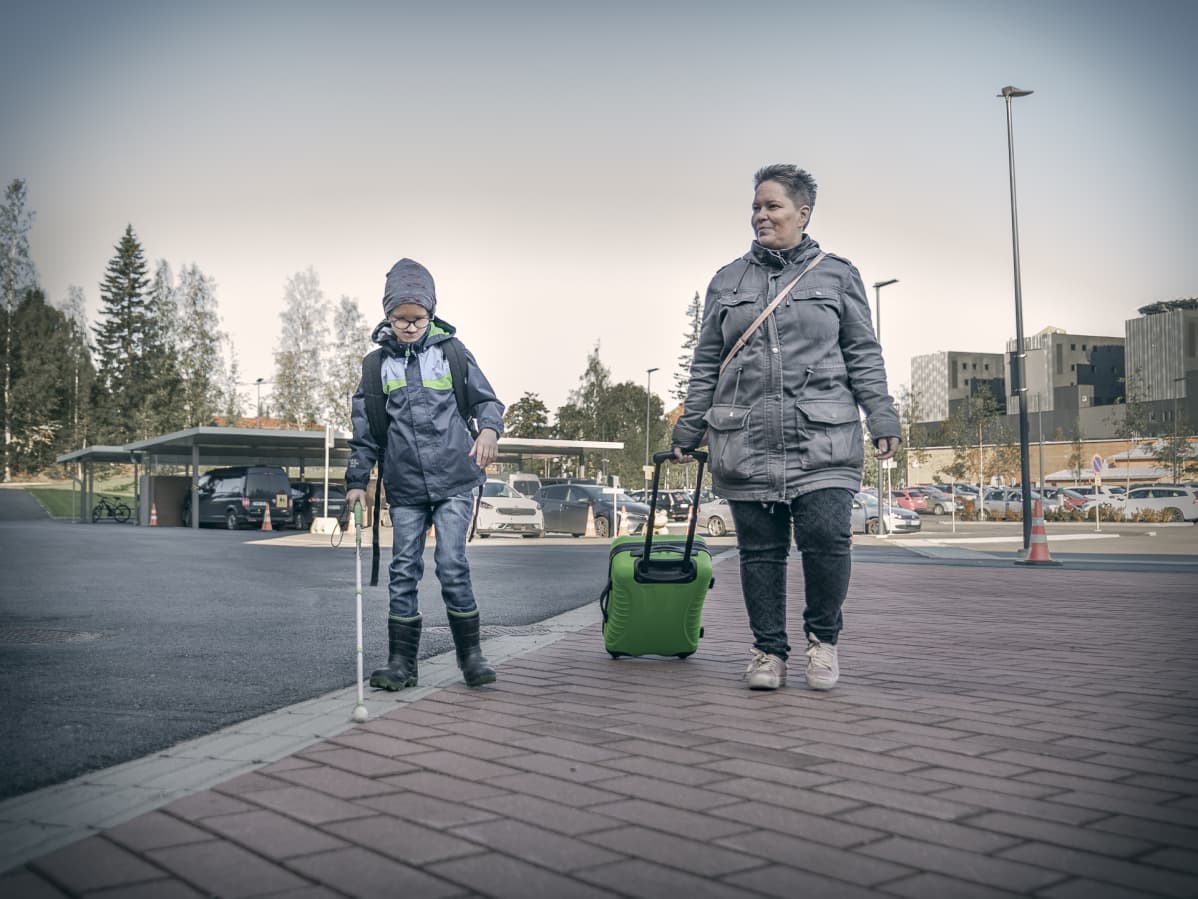 Äiti ja poika kävelevät kadulla