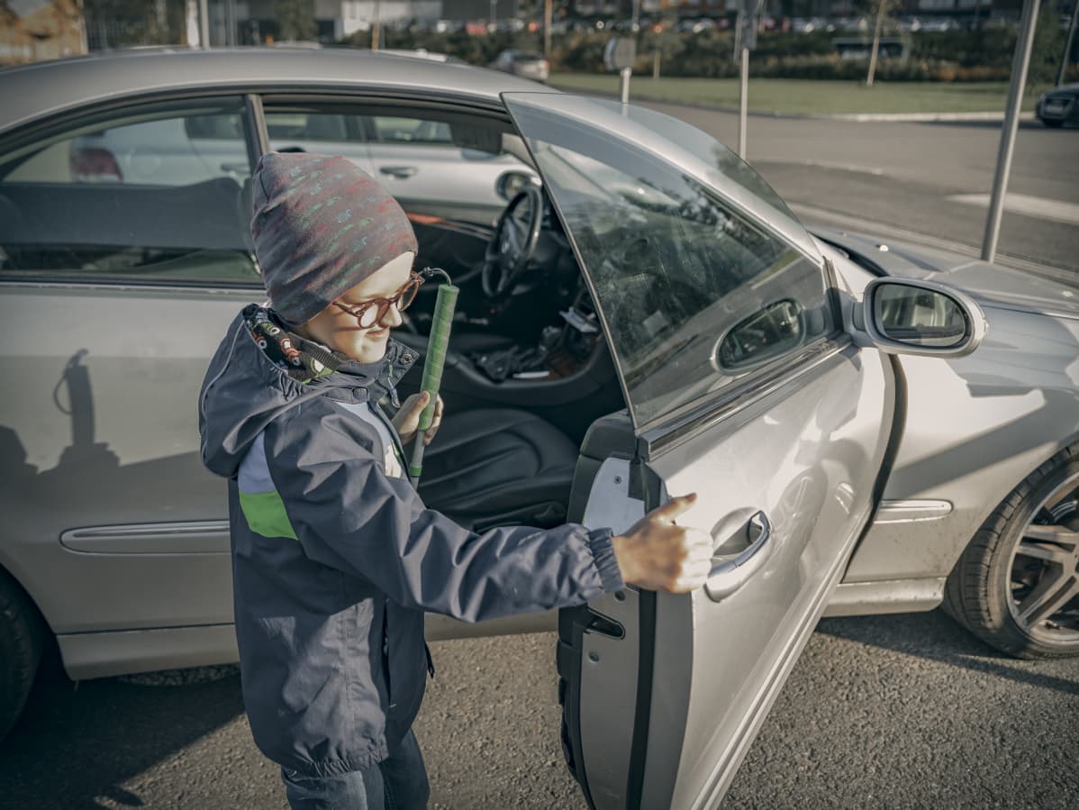 Poika astuu ulos autosta