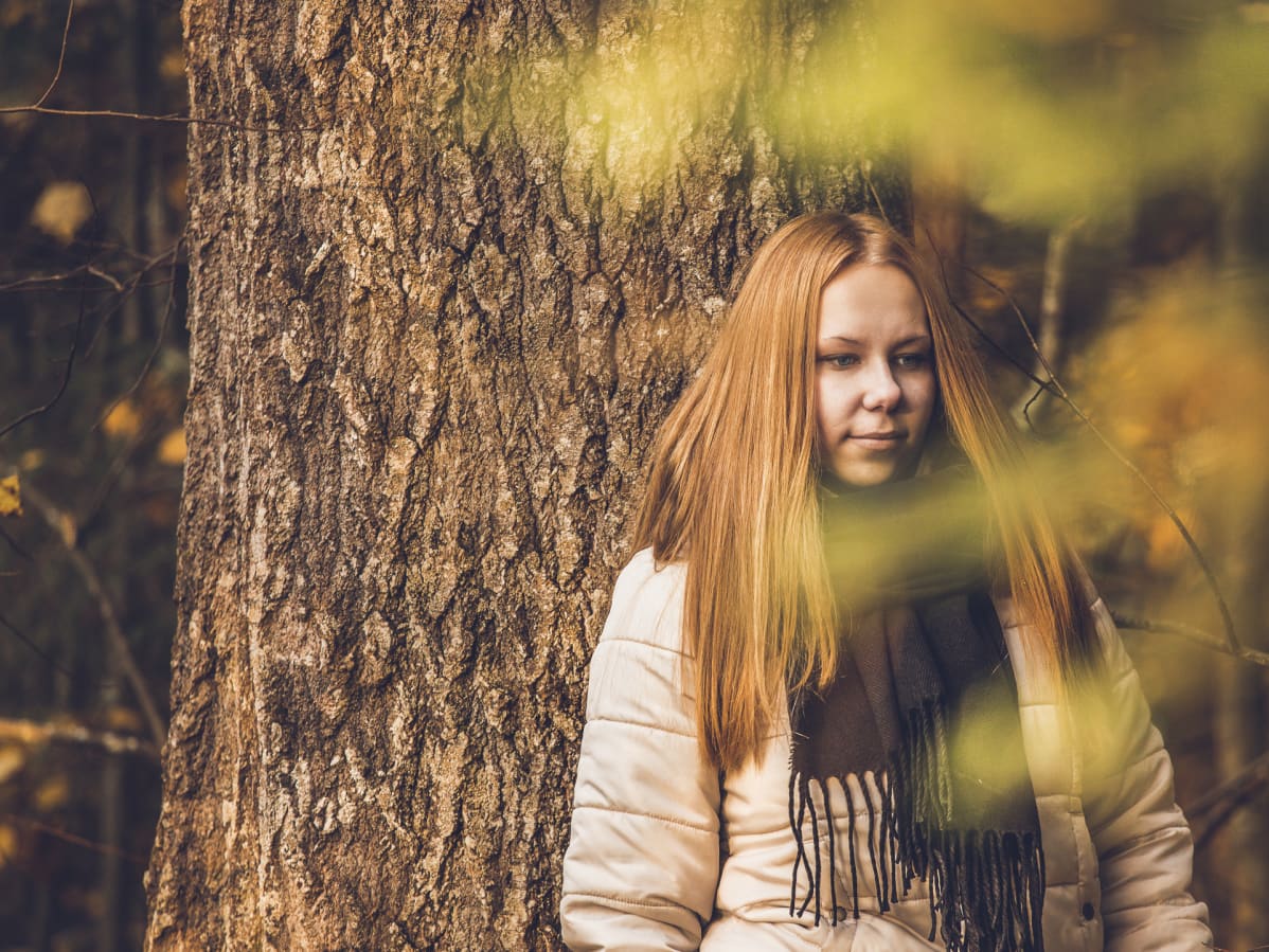 Nainen seisoo metsässä