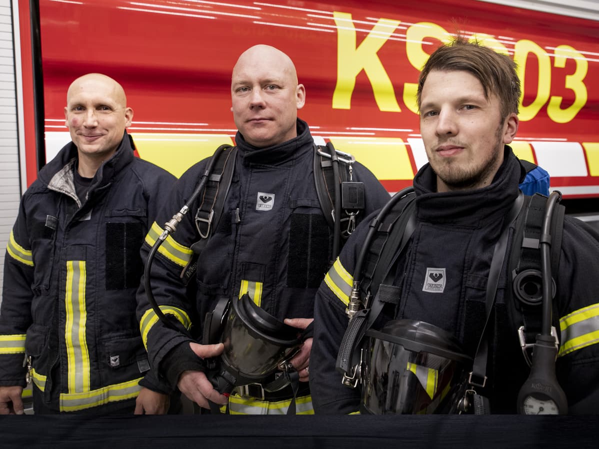 Palomiehet Hannu Kokkonen (vas,), Sami Sällinen ja Pekka Kolehmainen päällään savusukeltamisessa käytettävät paineilmalaitteet.