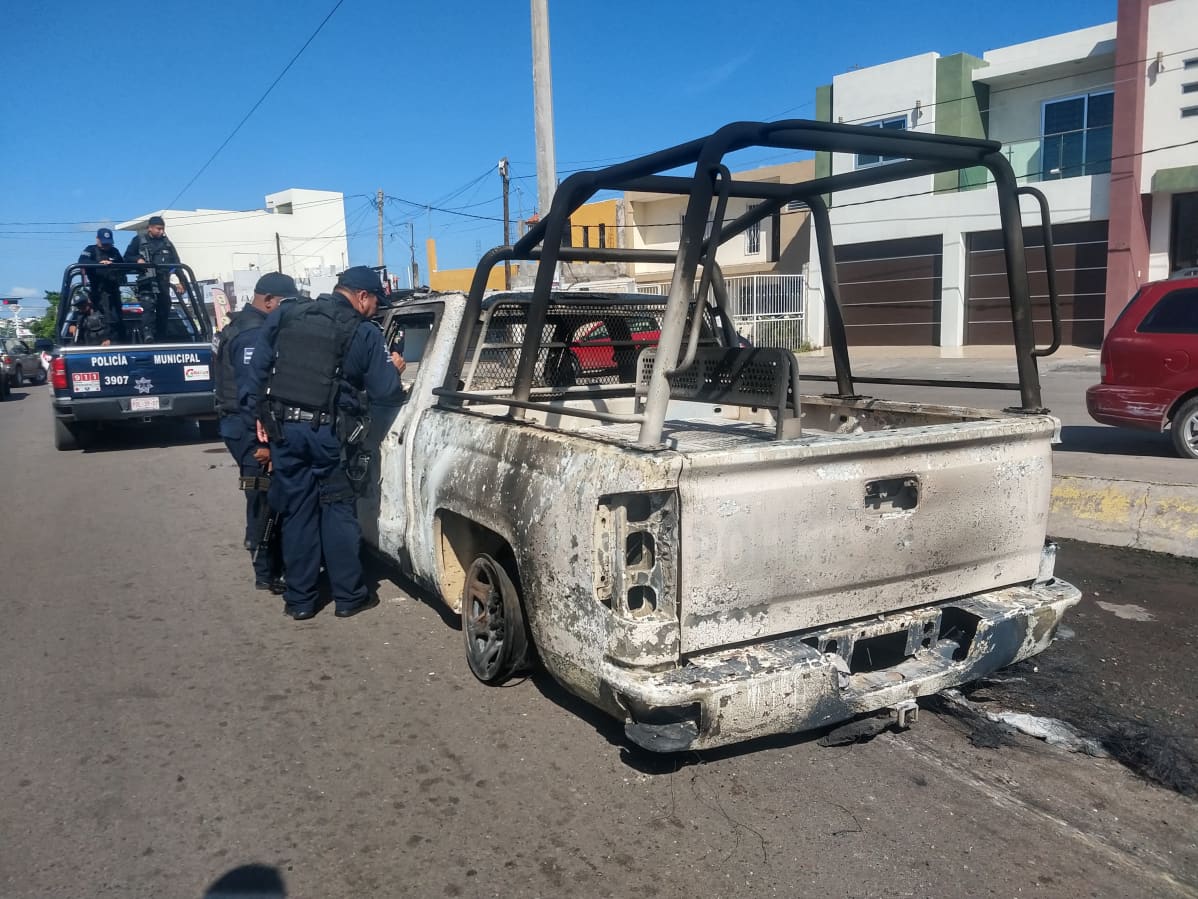Poliisit tutkivat palanutta autoa.