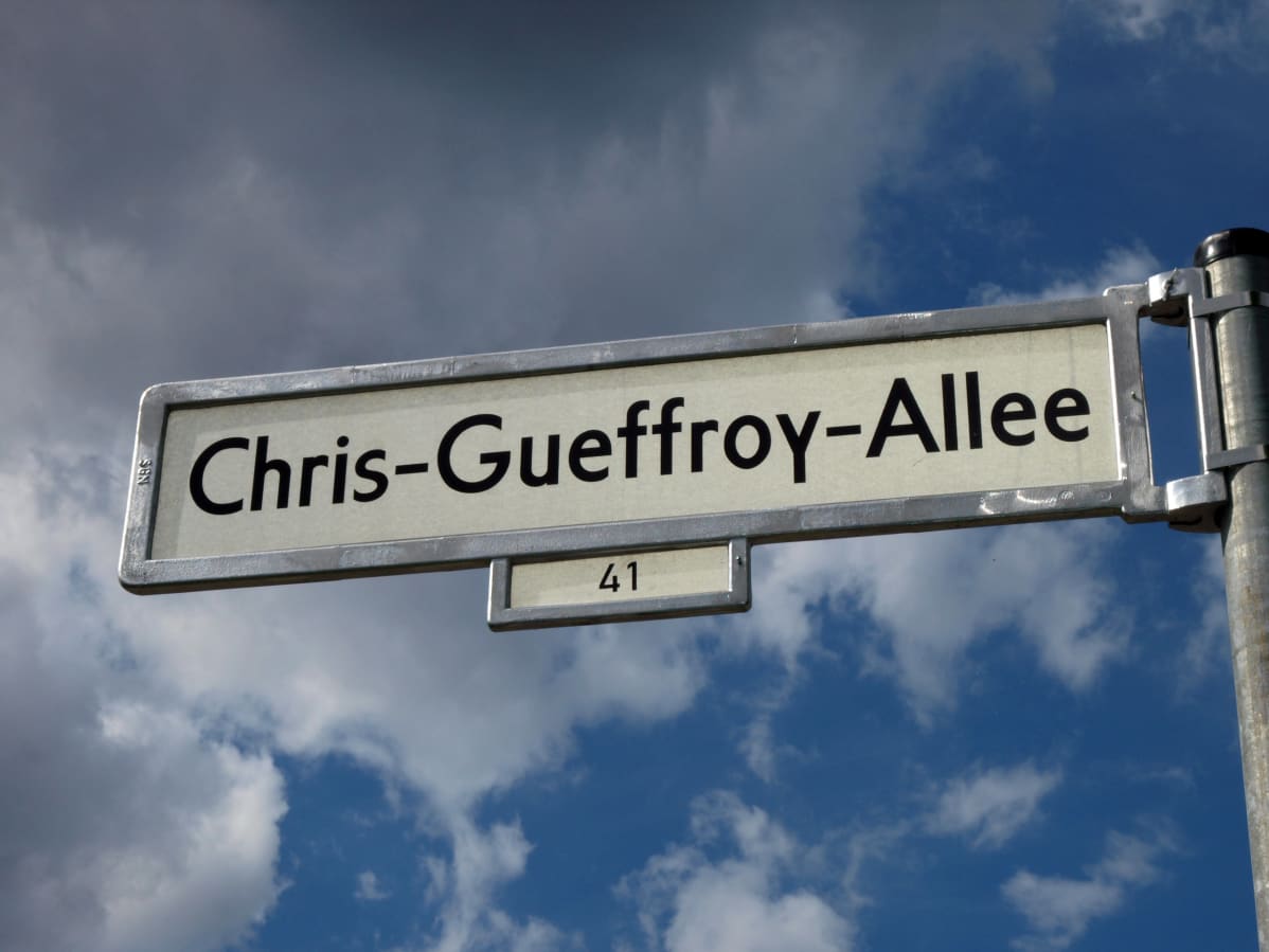 Chris Gueffroyn mukaan nimetyn kadun kyltti. Taustalla taivas ja pilviä.