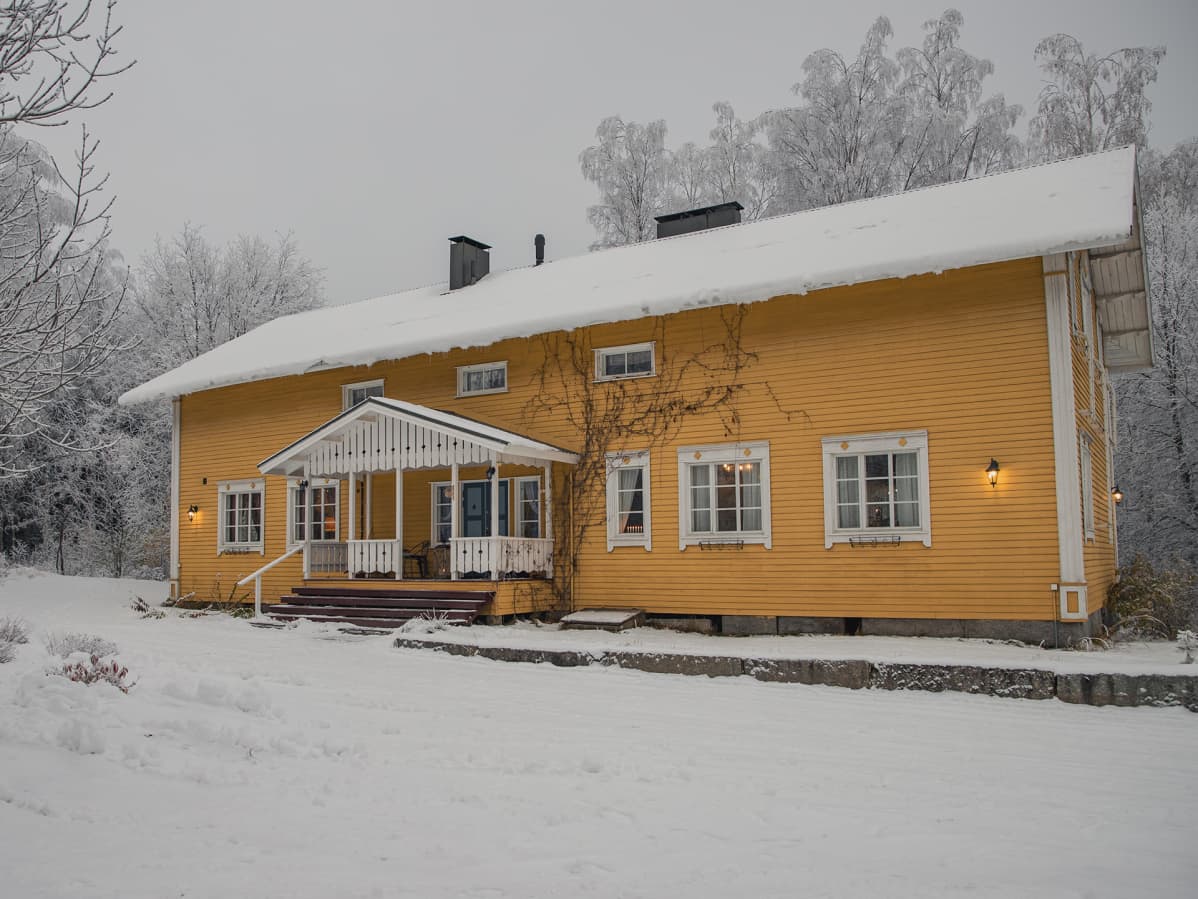 Keltainen kartano talvimaisemassa.