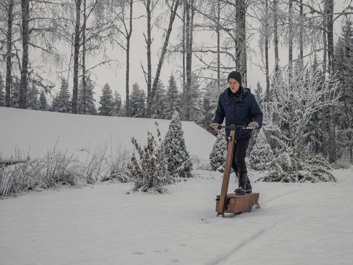 Poika ajaa sähkölumiskootterilla.