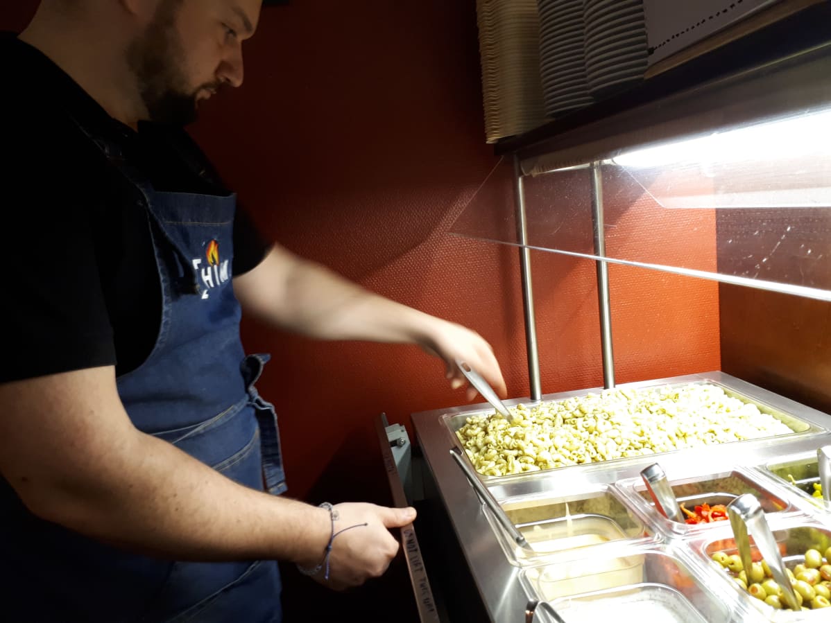Fatos Kavaja järjestelee tillimakaronia salaattilinjastolla