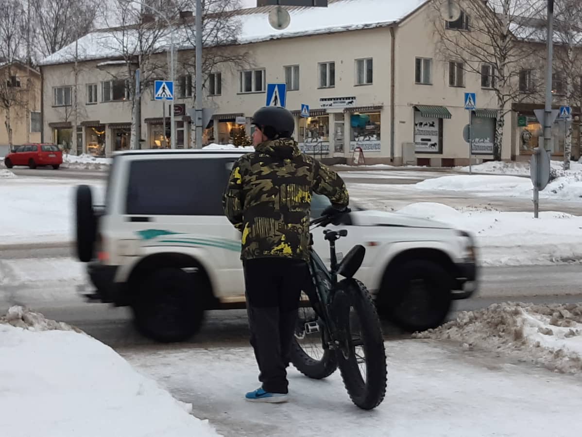 Pyöräilijä odottaa suojatien edessä Nurmeksen keskustassa.