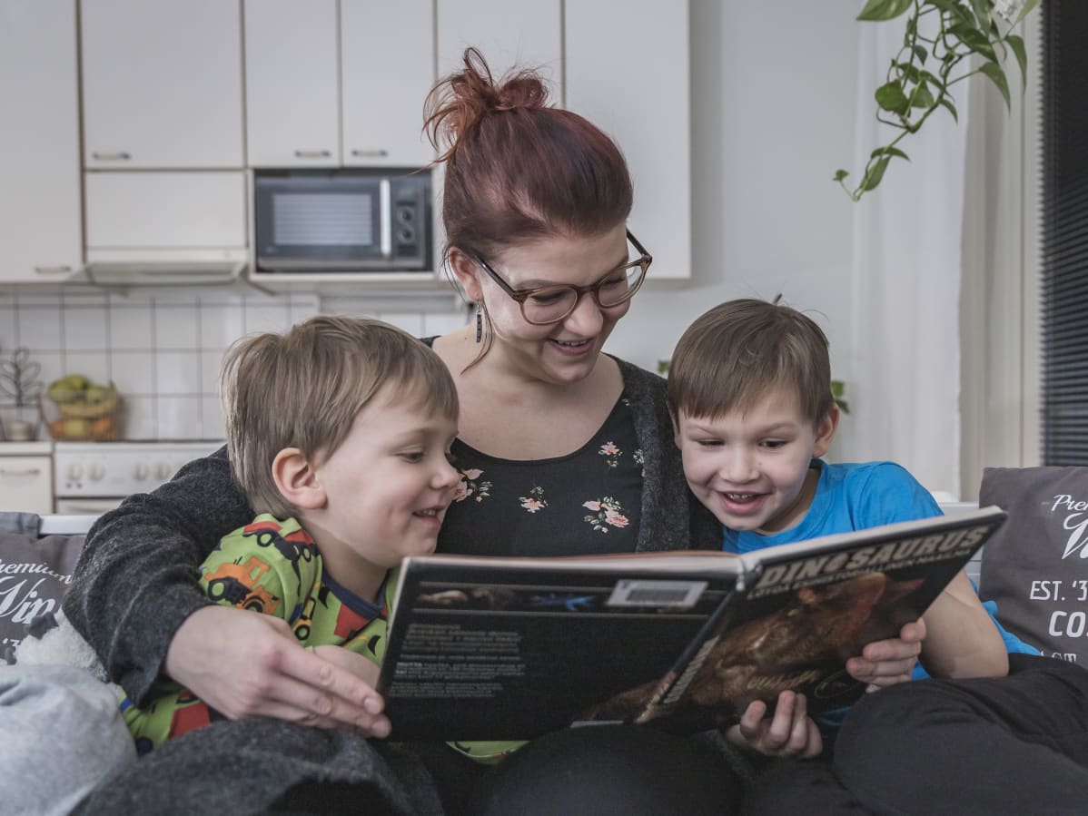 Vanhempi lukee lapsille kirjaa.
